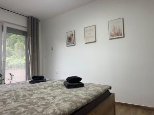 a bedroom with a bed with two black towels on it at Green river apartments in Lancovo