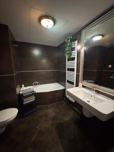a bathroom with a tub and a sink and a toilet at Apartamenty Sea Towers in Gdynia