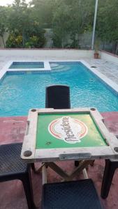 a table with a baseball logo on it next to a swimming pool at Hotel Rosangel in Estero Hondo