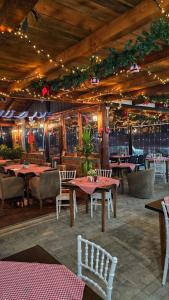 a dining room with tables and chairs and lights at Wooden Cabin 1 with Pool Access - Bate Bole Resort in Ohrid