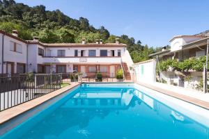 a swimming pool in front of a house at ESTRELLA de la SIERRA in Arroyo Frio
