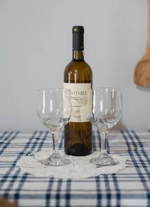 a bottle of wine and two wine glasses on a table at Πέτρινο Αλώνι in Panayía +42 photos