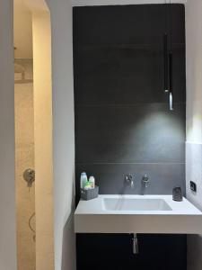 a bathroom with a sink and a black wall at Marta House 2 in Trapani +30 photos