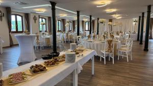 a dining room with tables and chairs with plates of food at Heritage Hall and More in Nagykálló