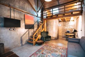 a living room with a couch and a tv on a wall at Terra Lodge in Ericeira