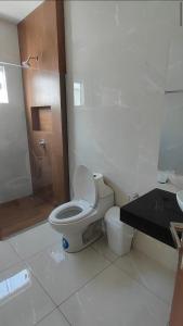 a white bathroom with a toilet and a sink at Casa Exclusiva Mar Adentro in Santa Cruz de la Sierra