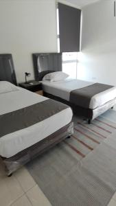 two beds sitting in a room with a carpet at Casa Exclusiva Mar Adentro in Santa Cruz de la Sierra