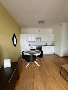 a kitchen with a table and chairs in a room at Apartamenty Sea Towers in Gdynia +19 photos