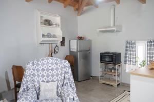 a kitchen with a chair and a refrigerator at Πέτρινο Αλώνι in Panayía