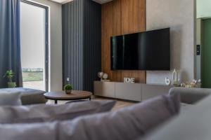 a living room with a flat screen tv on a wall at MB Villas in Vrnjačka Banja