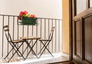two chairs and a table on a balcony with a plant at Centro A Casuzza in Palermo