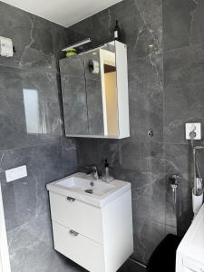 a bathroom with a white sink and a mirror at Villa Söderläget in Laholm