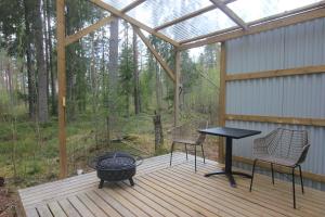a screened porch with a table and chairs on a deck at Forest Shed in Åsele