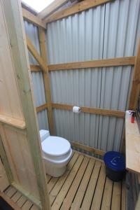 a bathroom with a toilet in a wooden structure at Forest Shed in Åsele +10 photos