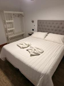 a white bed with two towels on top of it at Cristal Hotel in Eduardo Castex