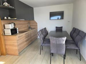 a kitchen with a table and chairs and a microwave at Vacation home Vilim in Kamešnica