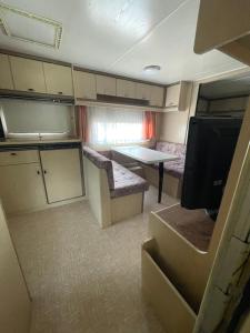 a small kitchen and living room in an rv at Campingplatz Wohnwagen mit Vorzelt in Affing +7 photos
