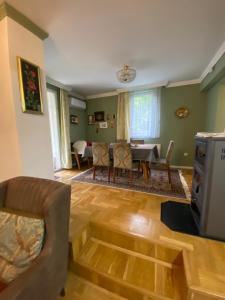 a living room with a couch and a dining room at Holiday Home Ilidza Rose in Sarajevo