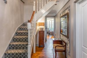 a hallway with a staircase with a chair and a table at Riverside Inn in Ely +32 photos