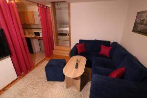 sala de estar con sofá azul y mesa en Apartment Vremeplov, en Travnik