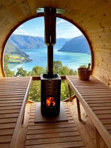 a fireplace in a cabin with a view of a lake at Raaum Gard, hytte 2 in Hafslo