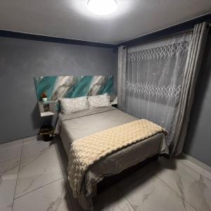 a bedroom with a bed with a curtain and a window at BEREA apartment 786 in Durban