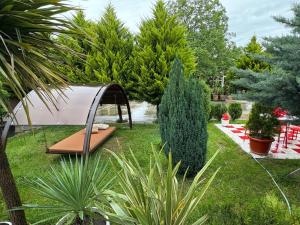 a garden with a swing in the grass at Green Land in Tbilisi City +32 photos