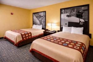 a hotel room with two beds and a picture on the wall at Super 8 by Wyndham Pasadena in Pasadena +6 photos