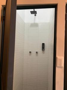 a shower with white tile and a glass door at Rio amazonas 7 in Mexico City
