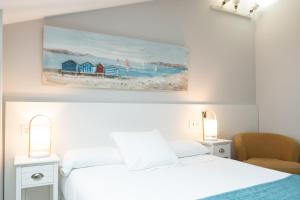 a bedroom with a bed and a painting on the wall at Pensión Txiki Polit in Zarautz +132 photos