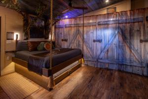 a bedroom with a wooden wall with a bed and a wooden floor at "Morning Wood" Luxury Treehouse Retreat Near Dollywood & Pigeon Forge in Sevierville