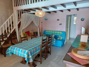 a dining room and living room with a table and chairs at kazAnne in Pointe-Noire