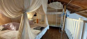 a bedroom with a canopy bed with a laptop on it at kazAnne in Pointe-Noire