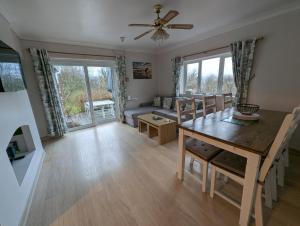 a dining room and living room with a table and a couch at Cwmbach Guest House in Neath