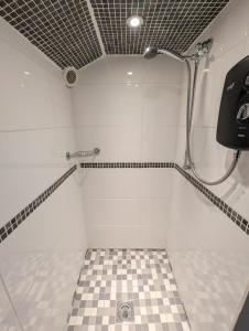 a bathroom with a shower with a checkered floor at Cwmbach Guest House in Neath +104 photos