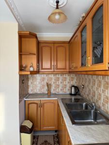 a kitchen with wooden cabinets and a sink at Guest House Dimos Kristi in Përmet
