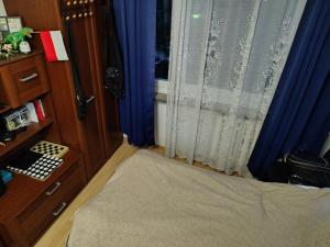 a bedroom with a bed and a window with blue curtains at Chelm Spoko Apartment in Chełm
