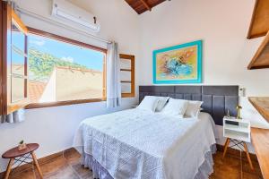 a bedroom with a bed and a large window at Piscina com ofurô/Churrasqueira/Sinuca e Ping Pong in Caraguatatuba +22 photos