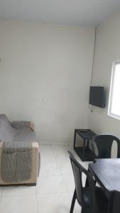 a bedroom with a bed and a table and chairs at Casinha Larithur in Beberibe