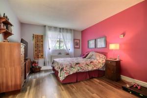 a bedroom with a pink wall and a bed at Saint Sauveur Dream in Saint-Sauveur-des-Monts