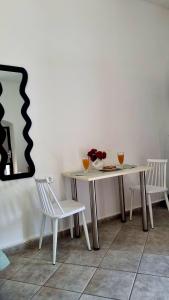 a table with two chairs and a table with flowers on it at Studio Marianna & George in Plátanos +7 photos