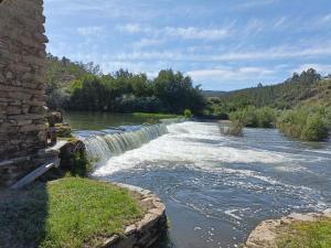 a river with a waterfall in the middle at Casa do Baloiço em Porto de Vacas Aldeias de Xisto in Janeiro de Baixo