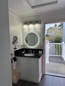 a bathroom with a sink and a mirror at River House Inn, a Baymont by Wyndham in Florence +18 photos