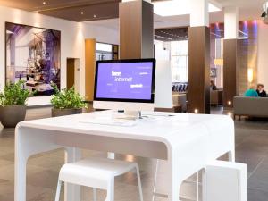 a white desk with a computer on top of it at Novotel Karlsruhe City in Karlsruhe