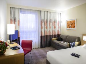 a hotel room with a bed and a couch at Novotel Reading Centre in Reading