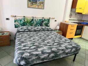 a bedroom with a bed with a black and white comforter at Ponzamania Casa dei fiori in Ponza