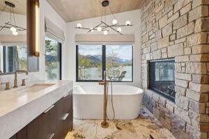 a bathroom with a large tub and a brick wall at Sisu Lodge by Canmore Premier in Kananaskis Village +84 photos