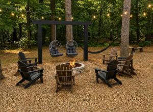 a group of chairs around a fire pit with a swing at Big Pine Gathering - Heated Pool - Pickleball - Sleeps 16 in Broken Bow