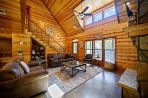 a living room with a couch and a table at Big Pine Gathering - Heated Pool - Pickleball - Sleeps 16 in Broken Bow +32 photos