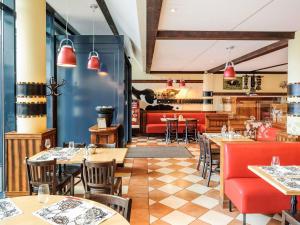 a restaurant with tables and chairs and a bar at ibis budget Genève Aéroport in Geneva
